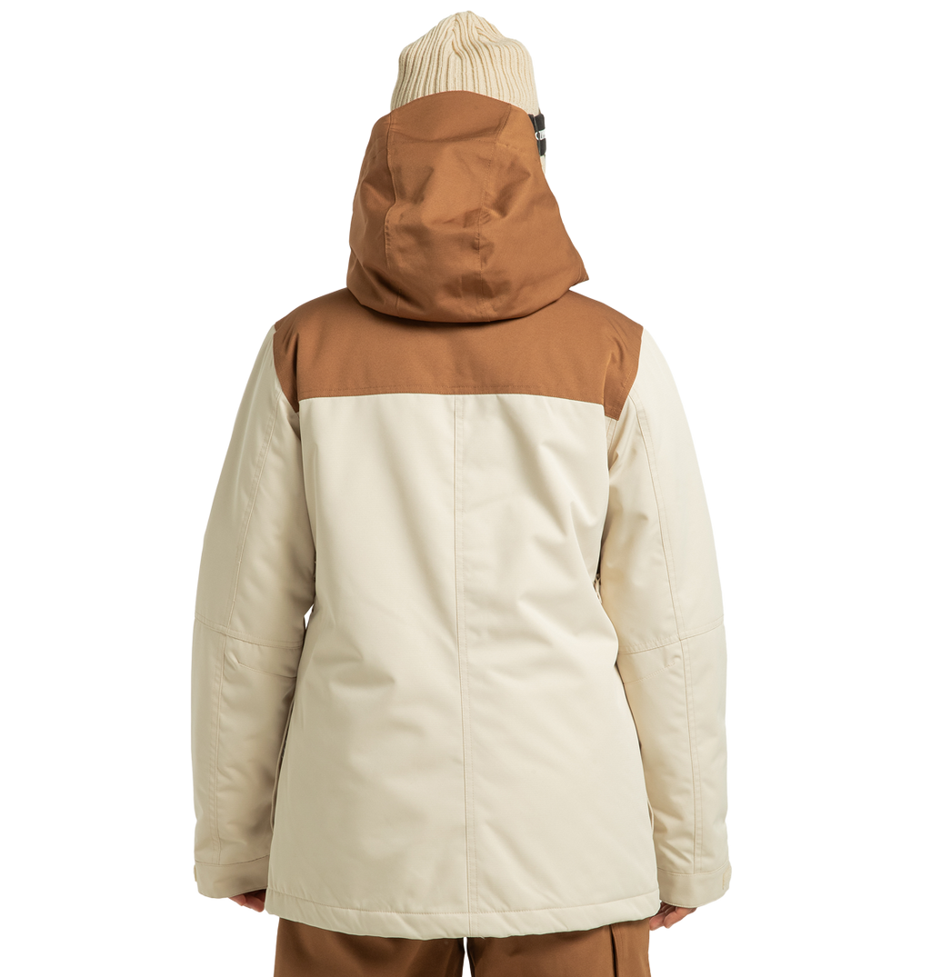 A person wearing the DC Shoes Women’s Liberate Insulated Jacket—a beige and brown hooded winter jacket constructed from recycled polyester—paired with a beige knit beanie is shown from the back, standing against a plain white background.