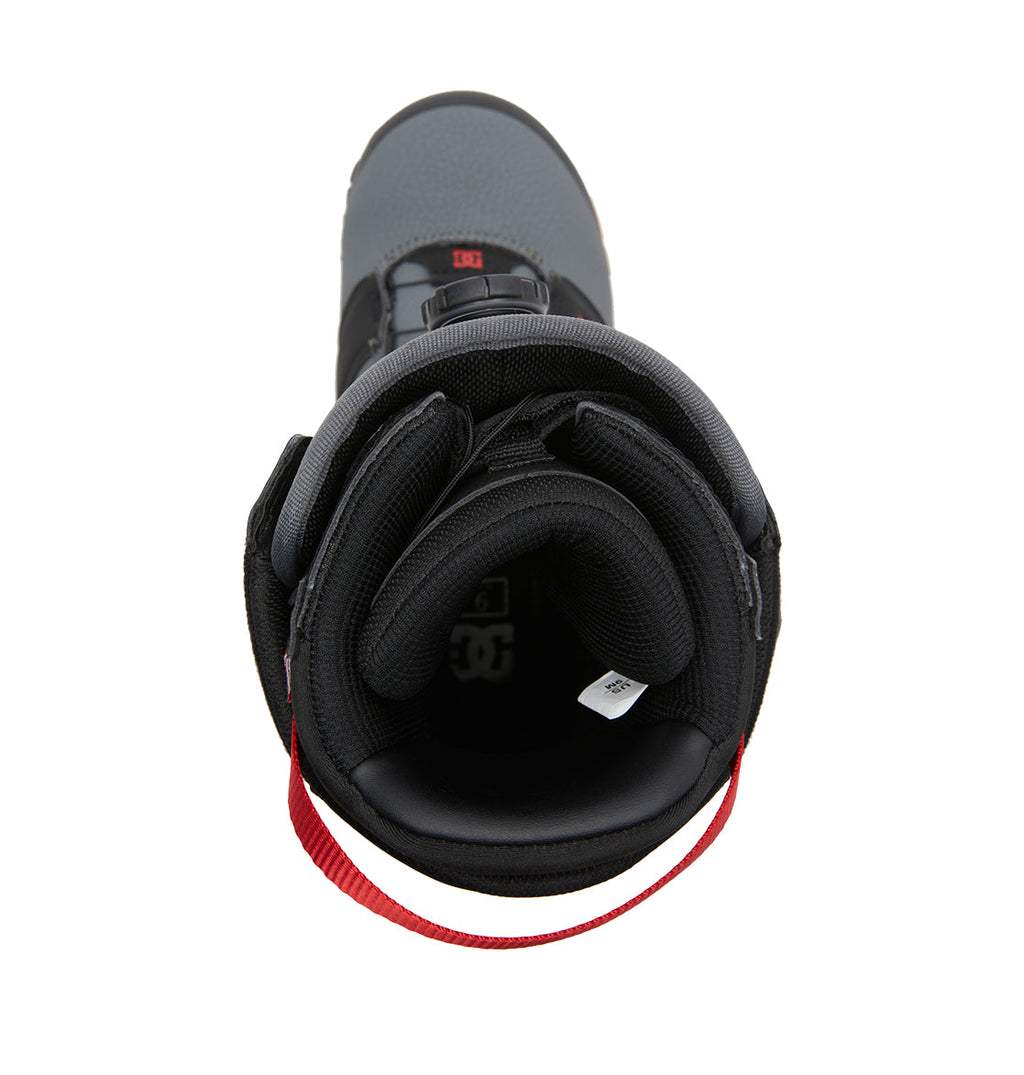 Top view of the DC Shoes Men’s Judge BOA® Snowboard Boots in black and gray, showcasing a red pull loop at the heel. The padded interior and tongue with a visible white tag are prominent, while the Dual Zone BOA® Fit System provides a secure and customizable fit.