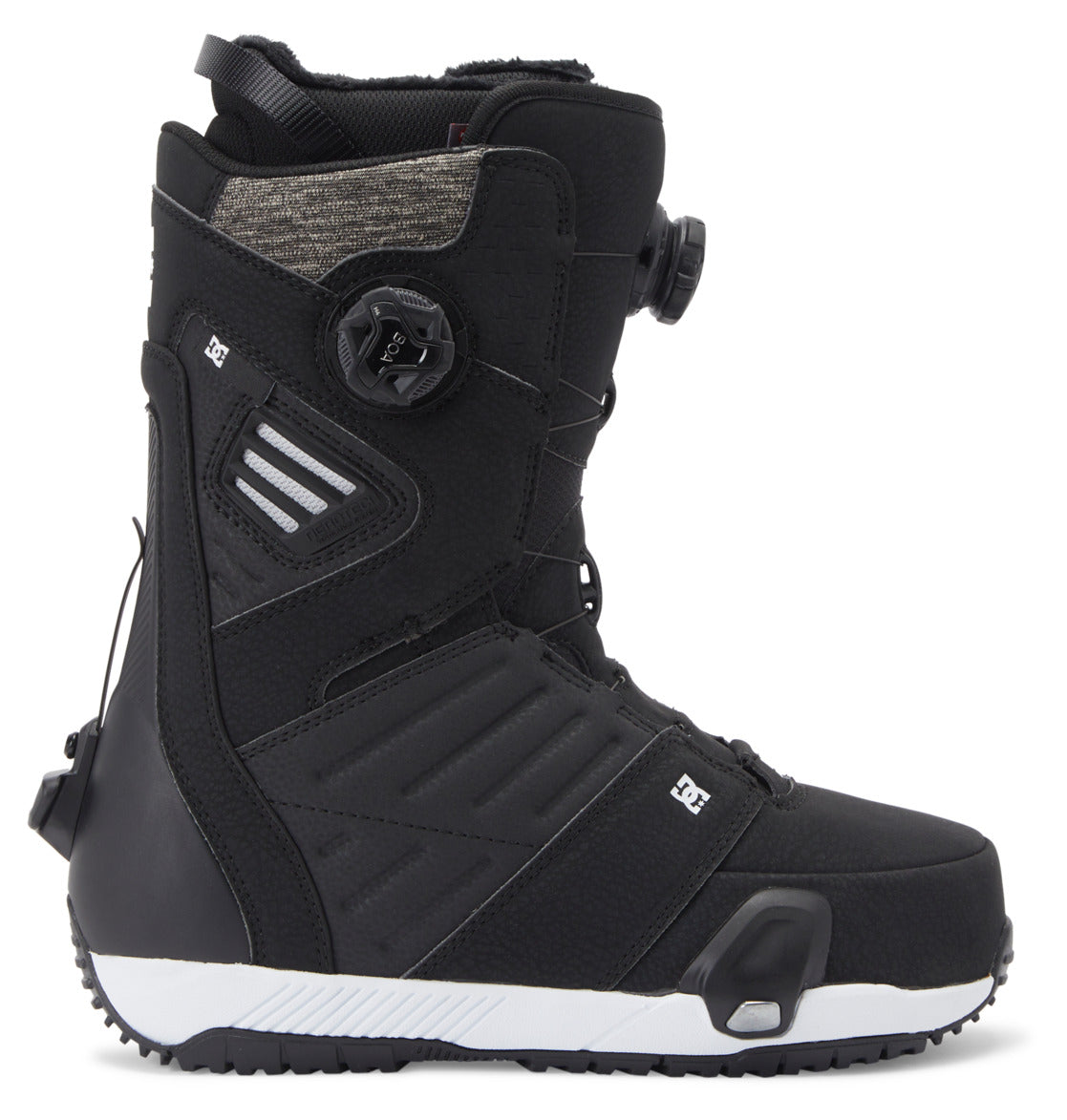 A pair of DC Shoes Men’s Judge Step On® BOA® Snowboard Boots in black, featuring a white sole, textured paneling, and adjustable BOA® Fit System dials on both the side and tongue for a secure fit. The boot is positioned upright, showcasing its side profile and distinct sole details.