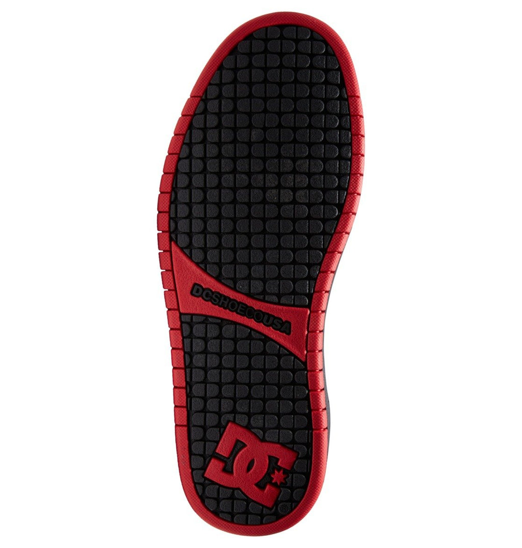 The Men’s Court Graffik Shoes by DC Shoes feature a black sole with a red border, a prominent red DC Star Logo at the heel, and the text “DCSHOECOUSA” in red near the arch. The tread showcases small square shapes, complementing the puffy silhouette and adding signature style to these men’s shoes.