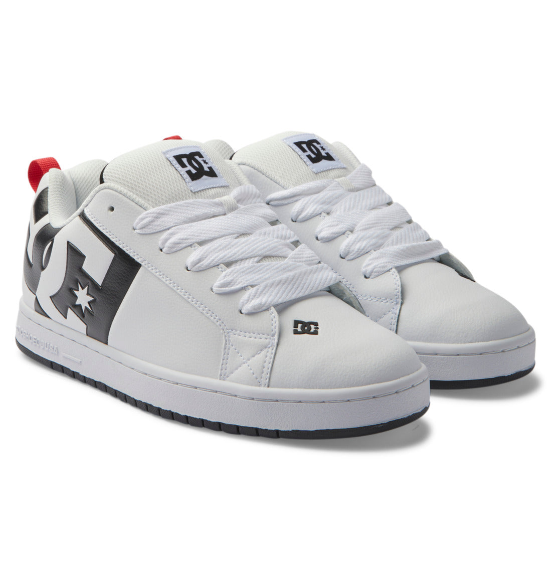 Introducing the Men’s Court Graffik Shoes by DC Shoes: a pair of white men’s skate shoes with bold black accents, striking red heel tabs, thick white laces, and prominent DC Star Logos displayed on the side, tongue, and near the toe. These shoes are completed with a stylish two-tone sole for added flair.