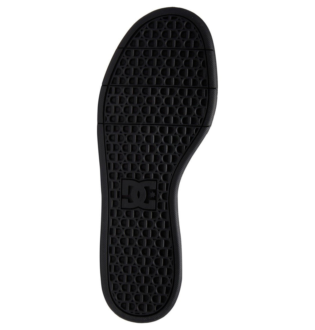 Black sole from the DC Shoes Men’s Crisis 2, featuring a textured grid pattern and a raised DC logo at the center. This performance cup sole is designed for durability, with curved edges and horizontal grooves at the toe and heel to improve grip and board feel.