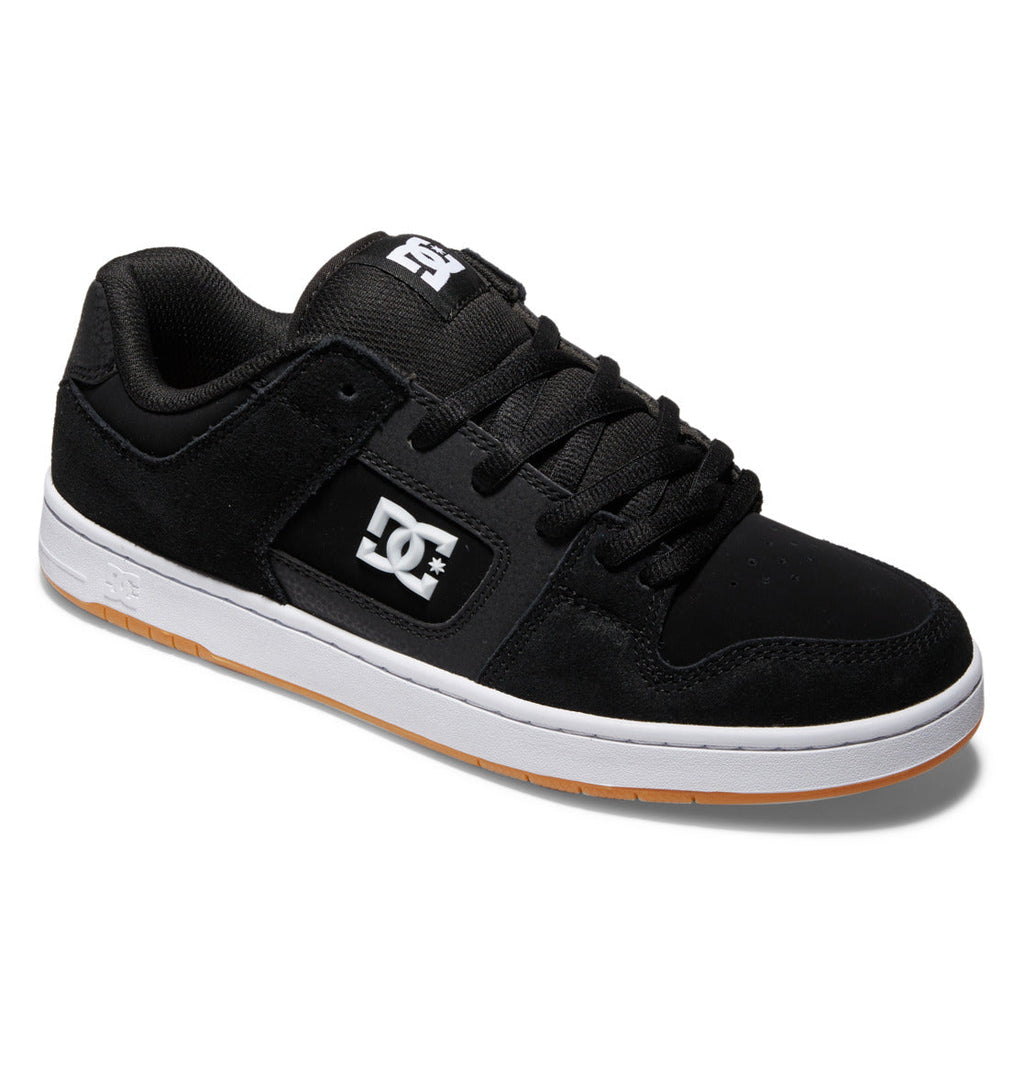 The Men’s Manteca 4 Skate Shoes by DC Shoes are shown at an angle on a white background, featuring a black upper with a white DC logo on the side, durable cupsole construction for enhanced longevity, impact protection insoles for superior comfort, a white midsole, gum outsole, and black laces.