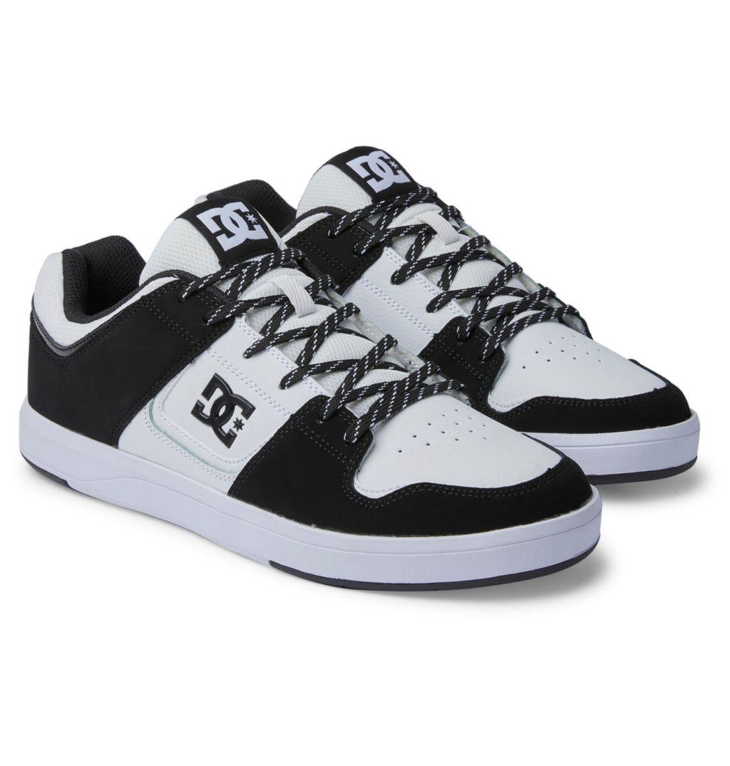 A pair of Men’s DC Cure Shoes by DC Shoes, featuring a black and white colorway, leather upper, patterned laces, logo detailing on the tongue and side, and crisp white soles—ideal for everyday wear—are displayed side by side on a plain background.