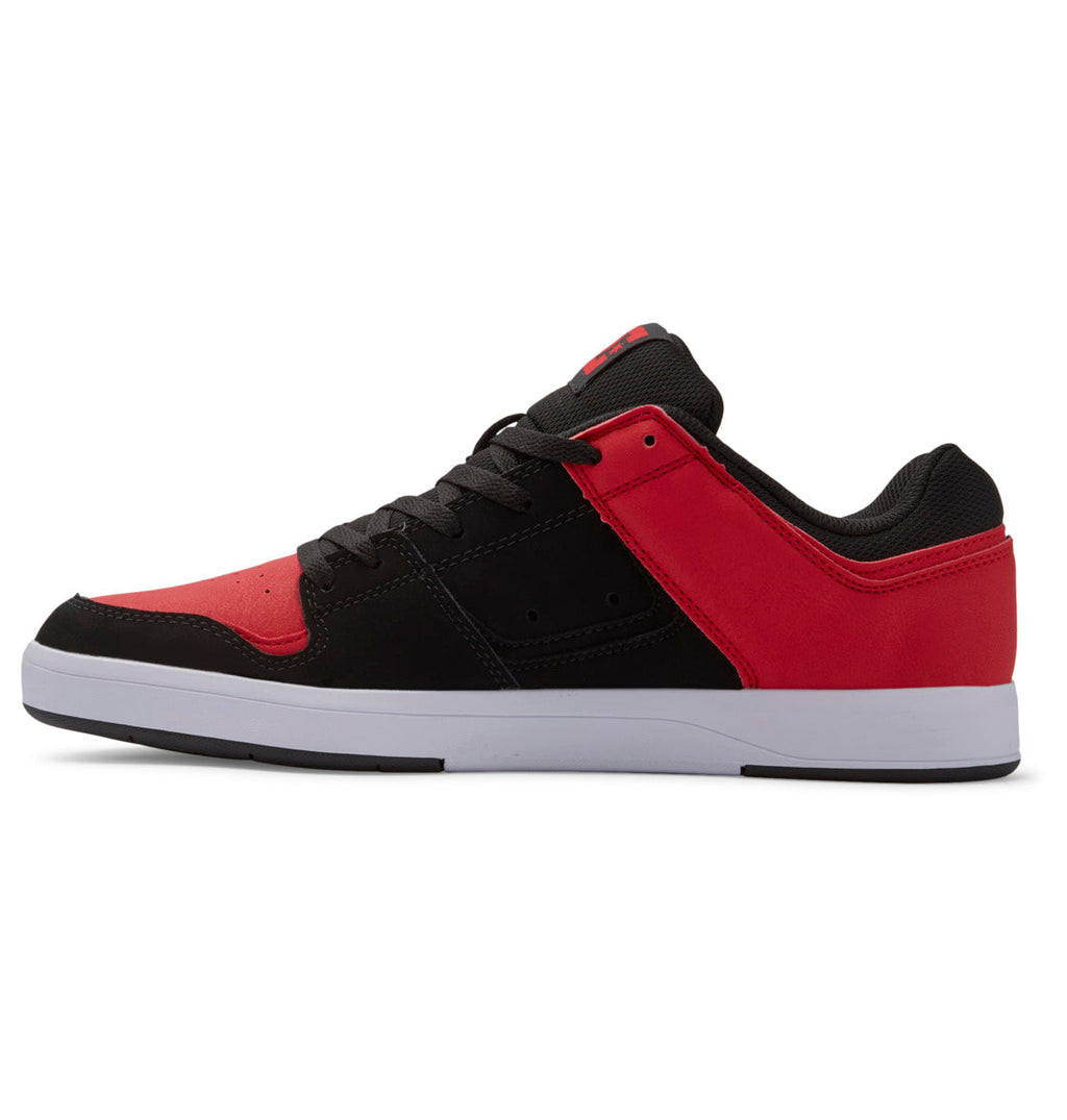 A side-profile view of the Men’s DC Cure Shoes by DC Shoes features a low-top design with a black, red, and dark gray leather upper, black laces, and a white sole—ideal everyday footwear from the DC Cure Shoes collection.