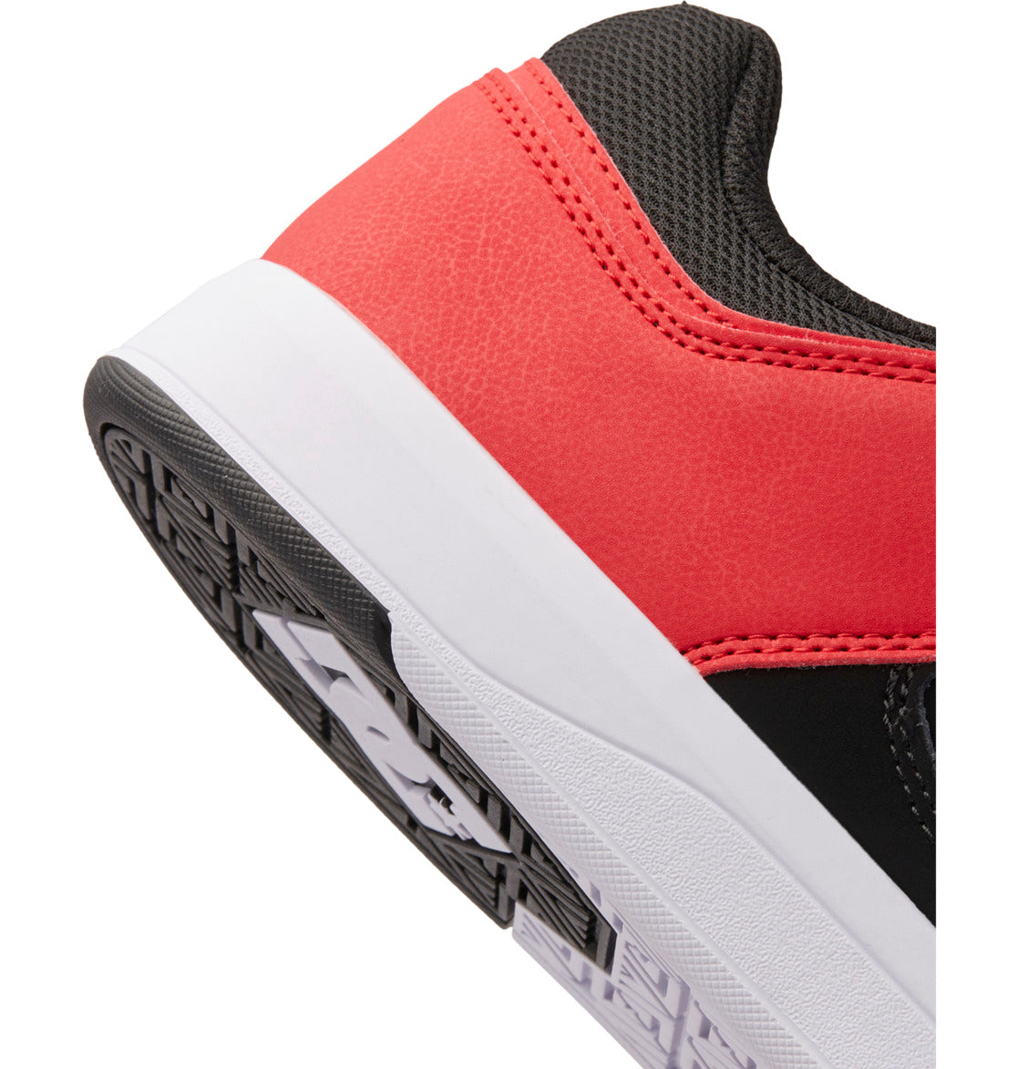 Close-up of the heel of a sneaker featuring a red leather upper, black mesh, white midsole, and textured black and white outsole—ideal for anyone seeking the style and comfort found in the Men’s DC Cure Shoes by DC Shoes.