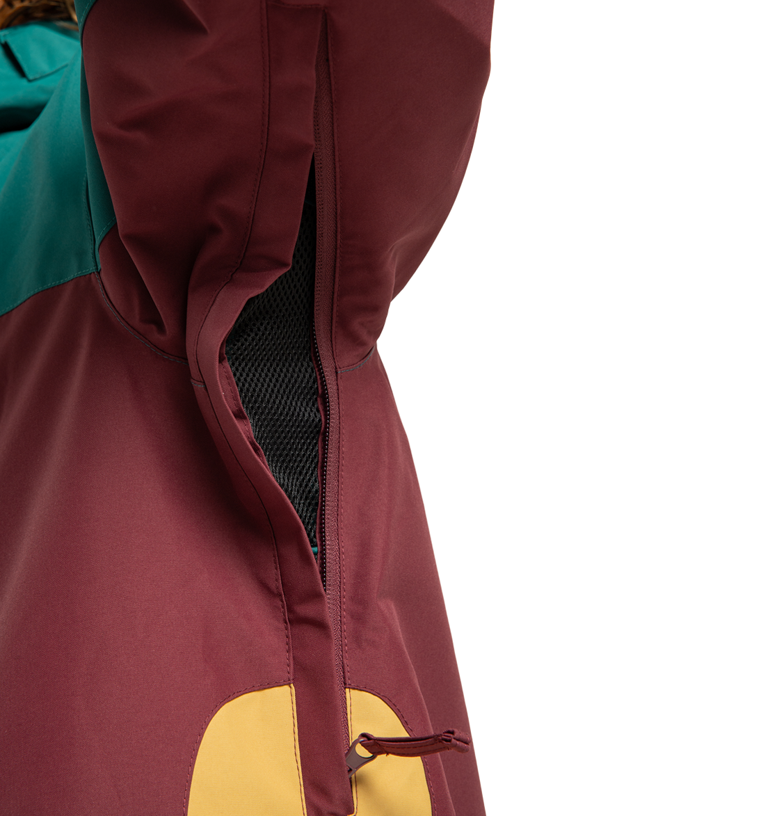 Close-up of the Men’s Defiant Insulated Jacket by DC Shoes, featuring burgundy, teal, and yellow panels with an open zippered vent lined in black mesh. Made from recycled polyester, this jacket keeps you comfortable and stylish on any winter adventure.