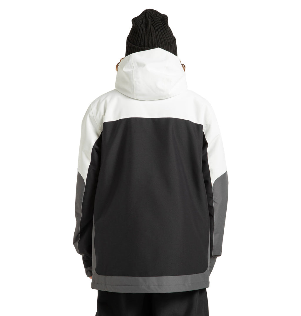A person is shown from the back wearing the DC Shoes Men’s Defiant Insulated Jacket, crafted from recycled polyester. This black and white jacket features a white hood and upper section with dark grey and black lower sections, paired with a black knit beanie—an ideal choice for any winter adventure.