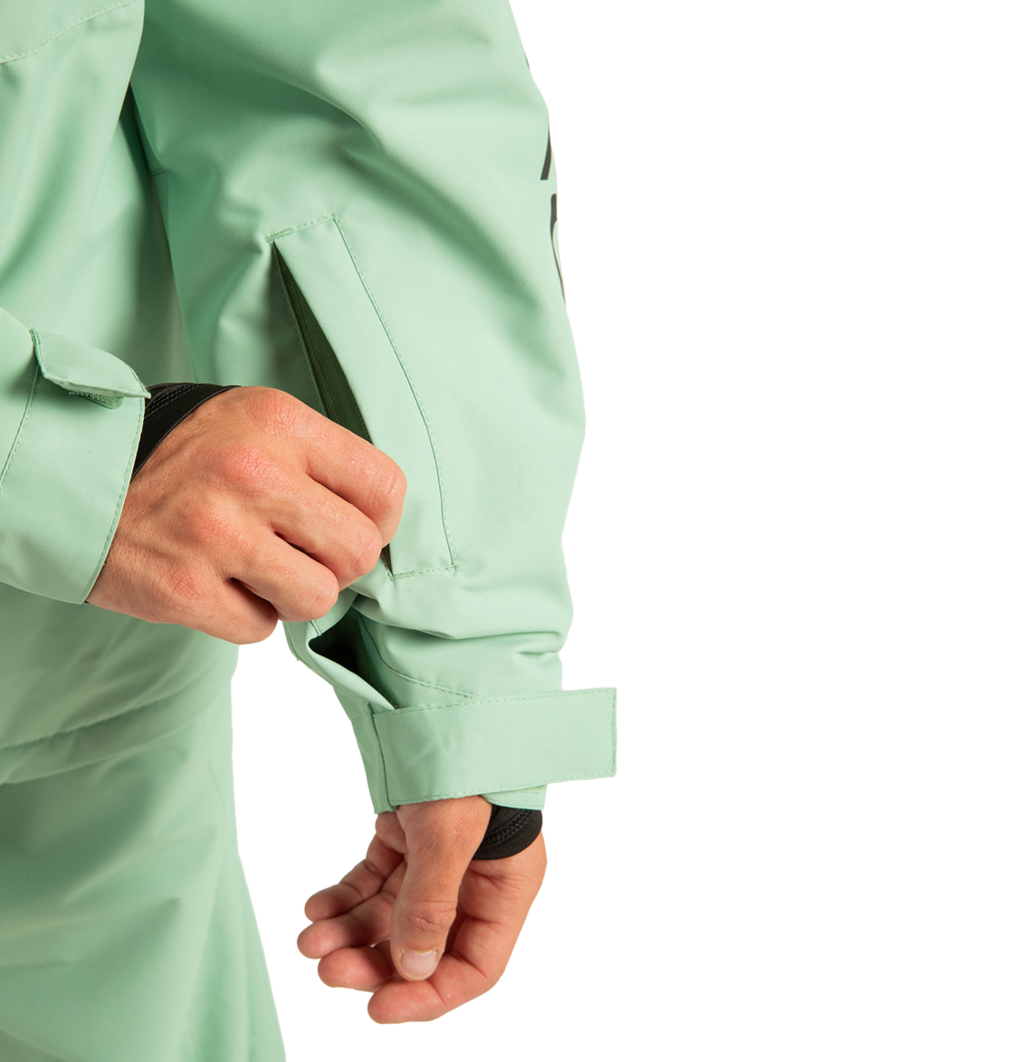 A person unzips a sleeve pocket on the DC Shoes Unisex Basis Insulated Jacket in light green, crafted from recycled polyester, with a Velcro strap secured at the wrist—ideal for winter adventures.