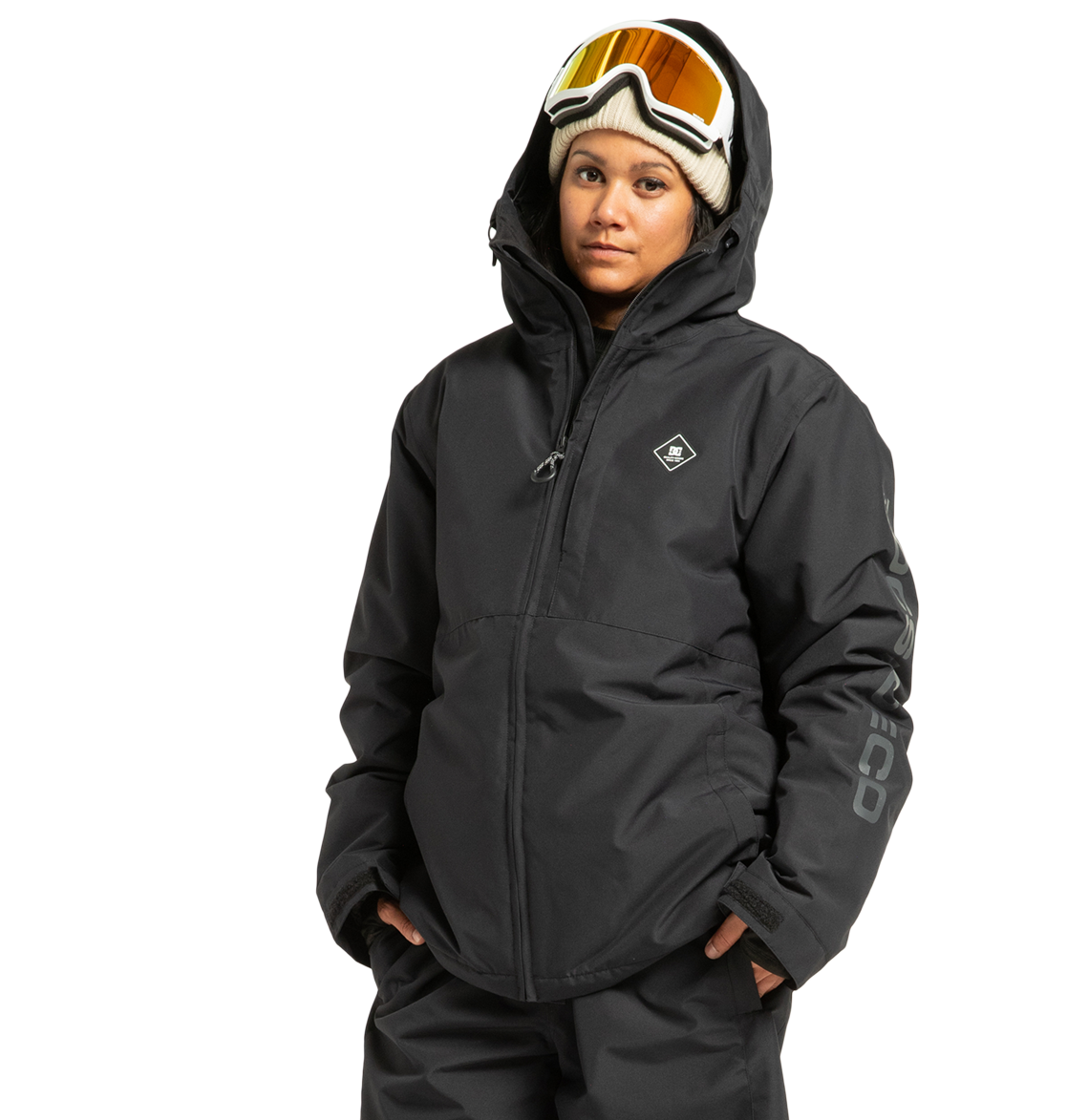 Wearing the DC Shoes Unisex Basis Insulated Jacket, along with black snow pants, ski goggles, and a beige beanie, a person stands with hands in pockets against a plain white background.