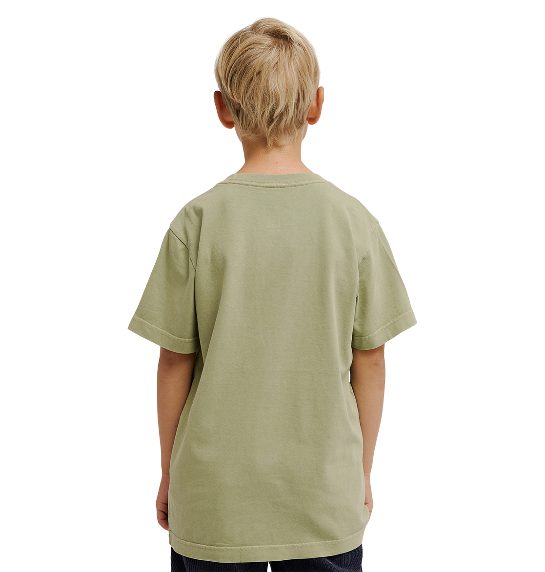 A young boy with short blond hair stands facing away, wearing the DC Shoes DC Speratic Tee Youth in a relaxed fit pale green graphic style and dark pants against a plain white background.