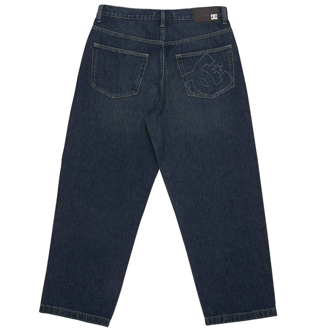 Back view of the Men’s Worker Baggy Denim Double That Jeans in dark blue from DC Shoes, featuring two rear pockets—one detailed with a stitched “6” and star design—and a small black DC logo patch on the waistband. These jeans capture vintage 90s skate style with their relaxed, straight-leg fit.