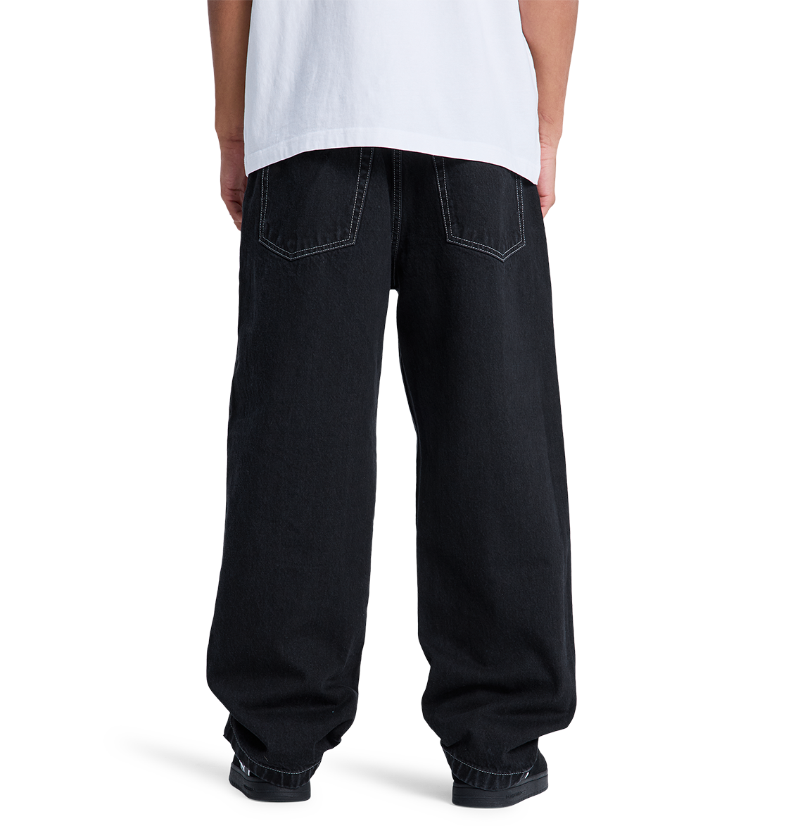 A person, seen from behind, wears a white t-shirt and DC Shoes Men's Baggy Denim Pant made from heavyweight denim, standing against a plain white background.