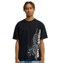 A young man stands against a plain white background, facing forward with a neutral expression, wearing the Men's DC Side Flame Tee from DC Shoes—an eye-catching black graphic t-shirt showcasing bold white abstract graphics and signature DC SHOES CO. artwork, perfect for his next skate sessions.