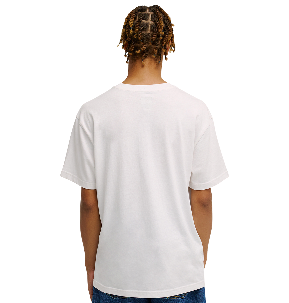A person with short, twisted hair is seen from behind, wearing a relaxed fit Men's DC Heritage Font Tee by DC Shoes in plain white, paired with blue jeans, standing against a plain white background.